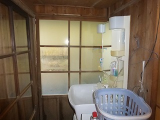リフォーム前の洗面化粧台と木製の引戸