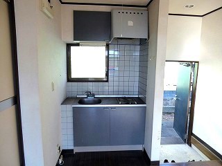 取替えリフォーム前のキッチンセットとタイルの壁